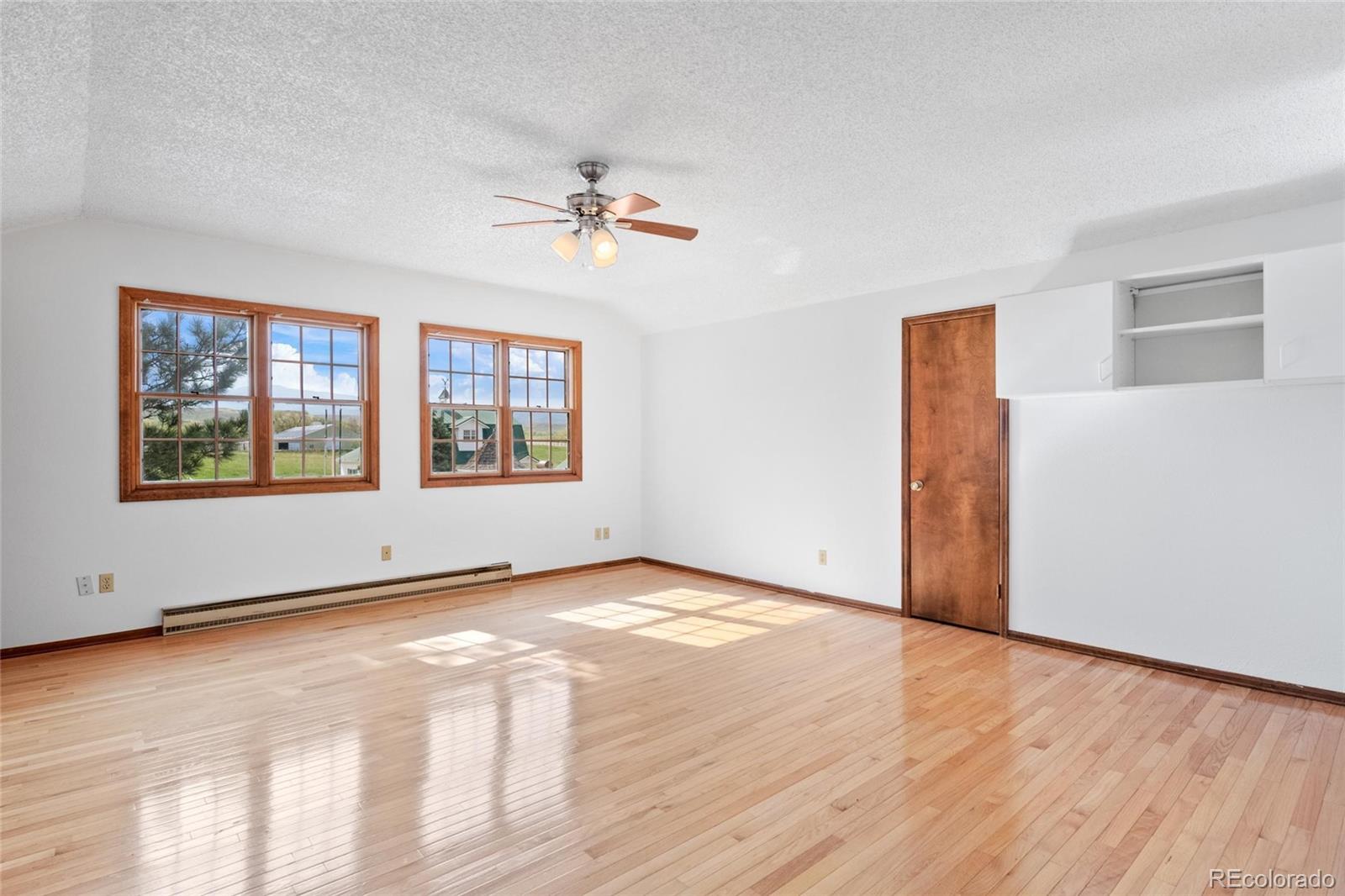 6231 Prospect Road Longmont, CO 80503 - Photo 15 of 45 a view of an empty room with a window and wooden floor