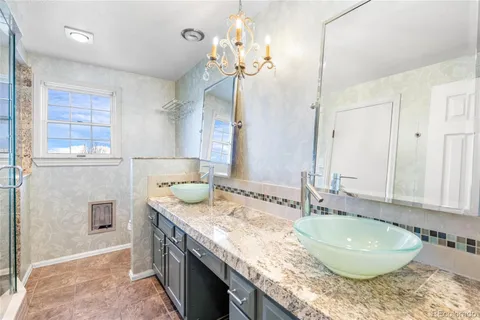 a bathroom with a granite countertop double vanity sink and a mirror