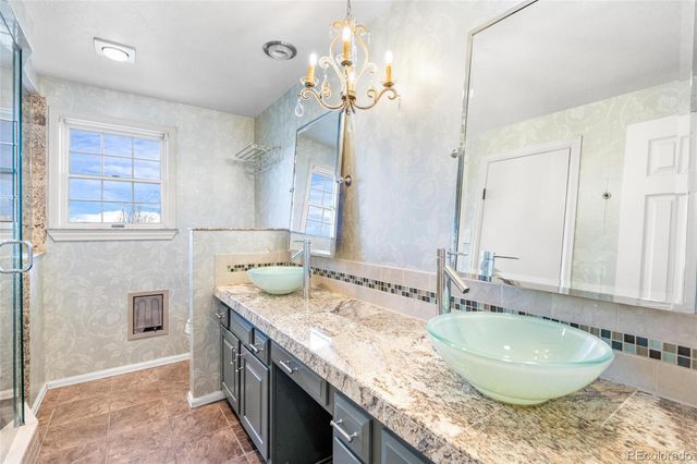 a bathroom with a granite countertop double vanity sink and a mirror