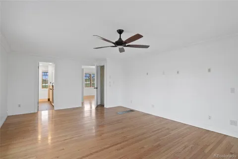 a view of an empty room with window and wooden floor