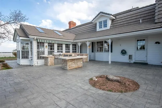 a view of a house with backyard and sitting area