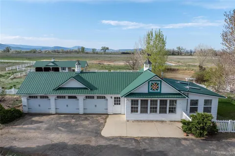 a front view of a house with a yard and lake view