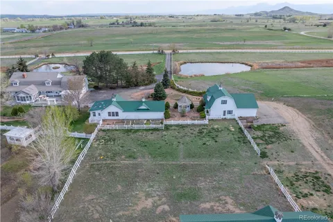 an aerial view of a house with a garden and lake view