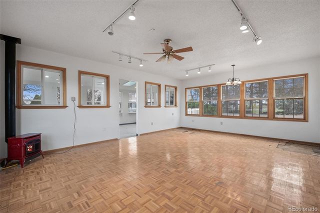 a view of an empty room with a window and fireplace
