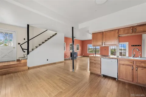 a kitchen that has a lot of cabinets and wooden floor