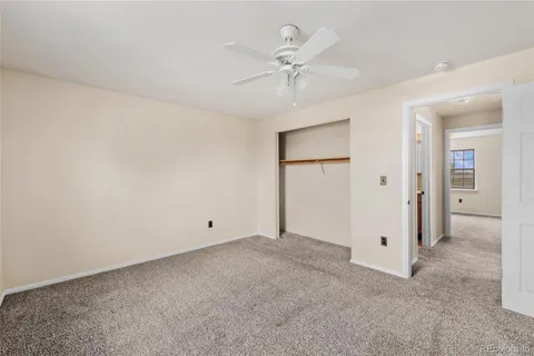 an empty room with a ceiling fan and a window