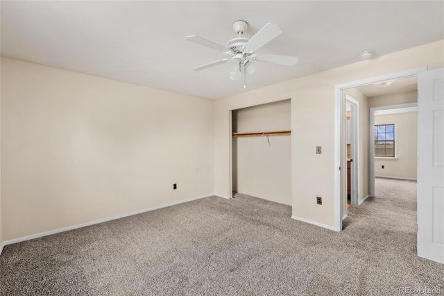 an empty room with a ceiling fan and a window