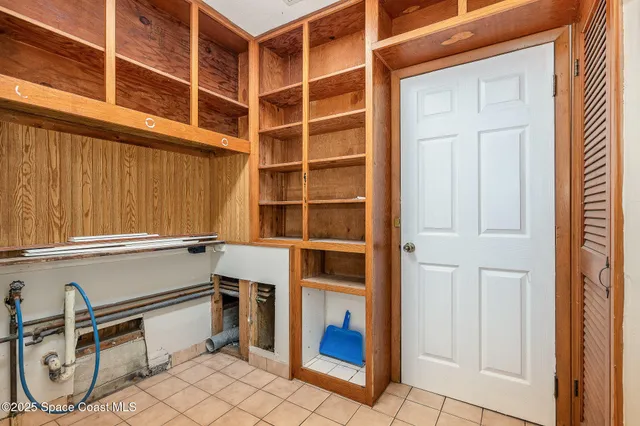 a view of an empty room with wooden floor and cabinets