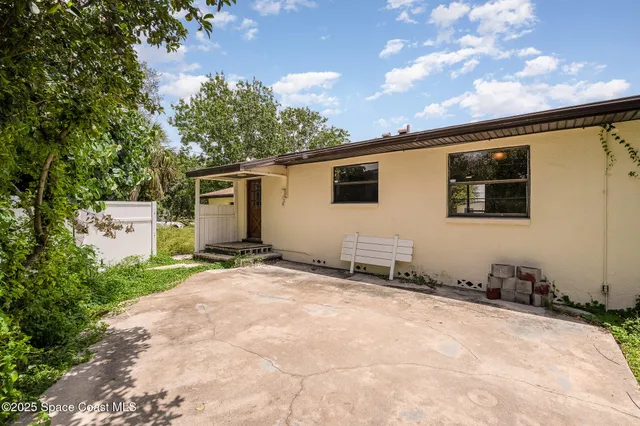 a backyard of a house with table and chairs