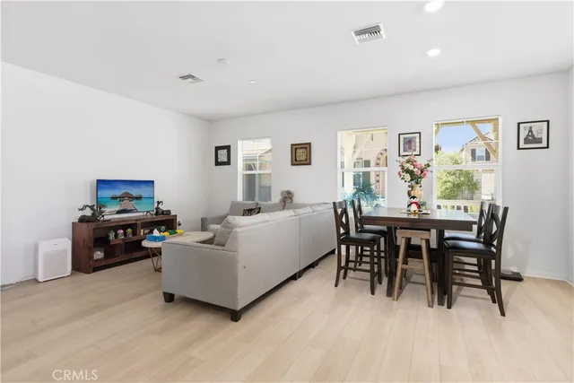 a living room with furniture a dining table and a wooden floor