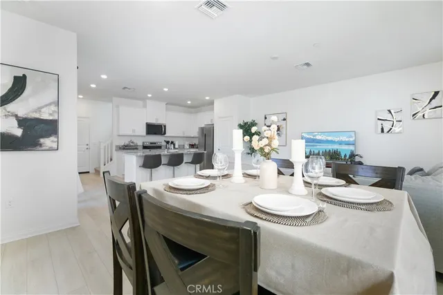 a kitchen with a dining table chairs and refrigerator