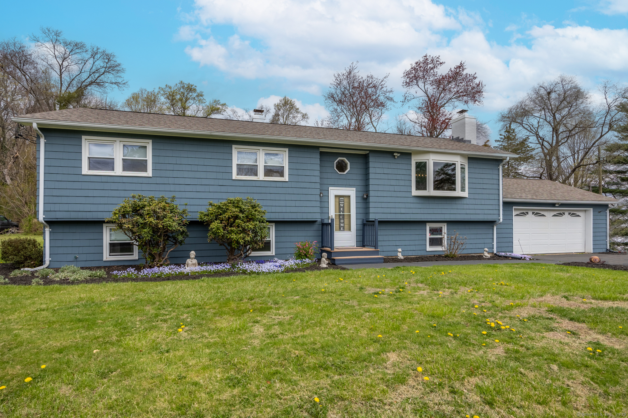 a view of a house with table and chairs next to a yard