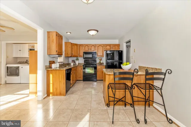 a kitchen with stainless steel appliances granite countertop a stove top oven a sink dishwasher and a microwave oven with cabinets