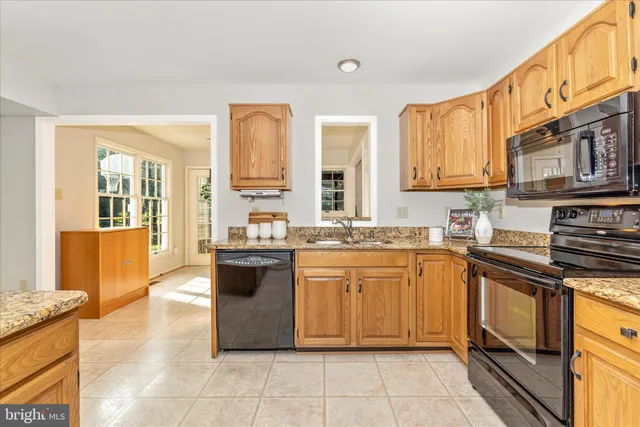 a large kitchen with granite countertop a sink and cabinets