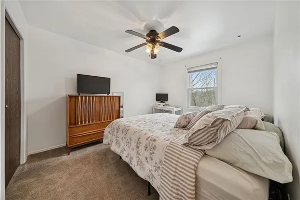 a bedroom with a bed and a flat tv screen on a dresser