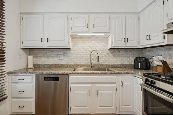 a kitchen with a sink a stove and cabinets