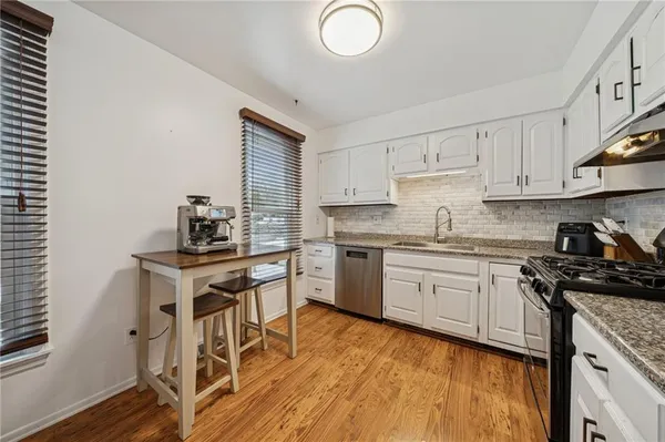 a kitchen with granite countertop white cabinets and appliances