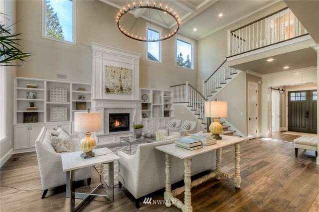 a living room with furniture a fireplace and a chandelier
