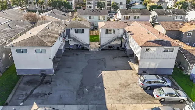 an aerial view of a house with cars parked