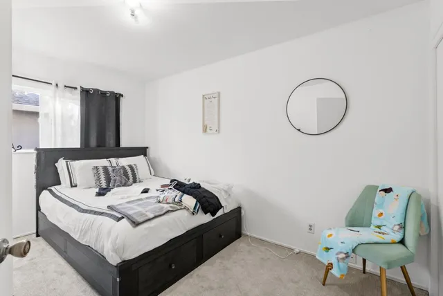 a bedroom with a bed and a flat tv screen on a dresser