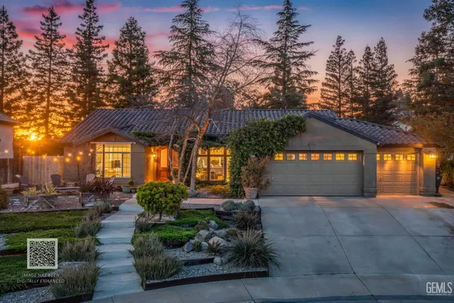 a front view of a house with a yard and trees