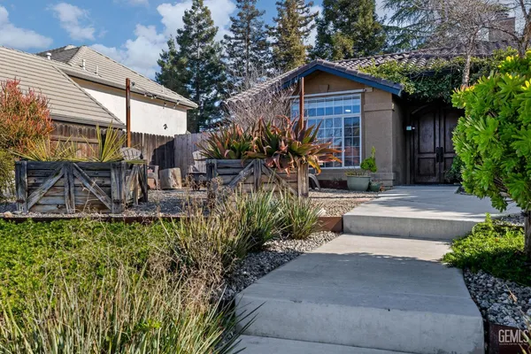 a view of a backyard with wooden fence and a large tree