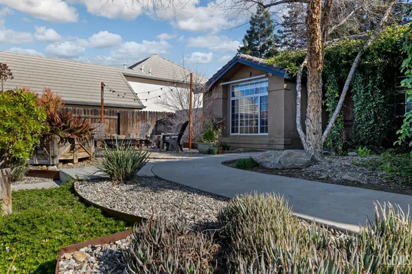 a view of a backyard with table and chairs under an umbrella