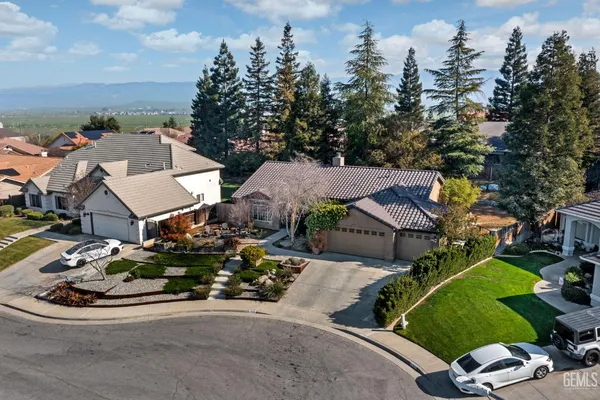 an aerial view of a house with a garden and mountain view in back