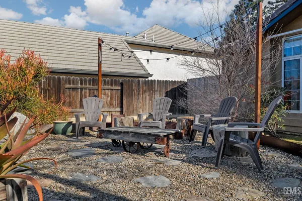 a view of a dinning tables and chairs in backyard of the house