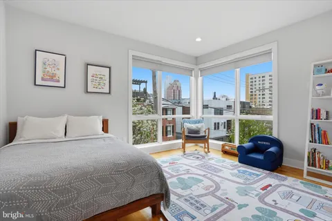 a bedroom with a bed a couch and a large window