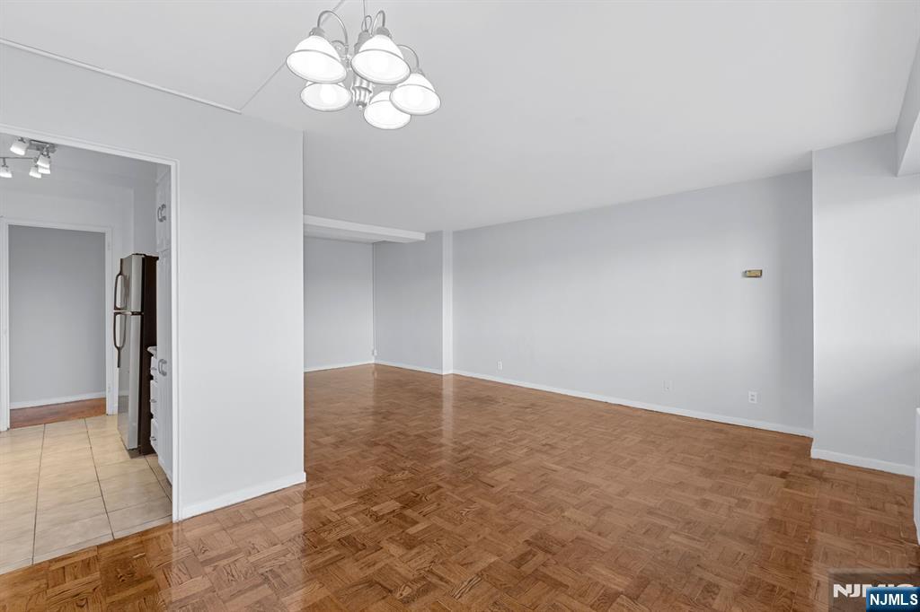 377 South Harrison Street, Unit 9G East Orange, NJ 07018 - Photo 5 of 27 a view of an empty room with wooden floor and a chandelier