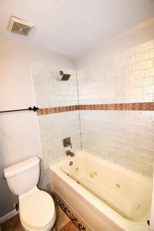 a bathroom with a bathtub and toilet