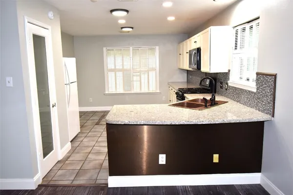 a kitchen with a sink a stove and cabinets