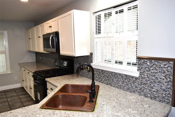 a kitchen with a sink a stove and cabinets