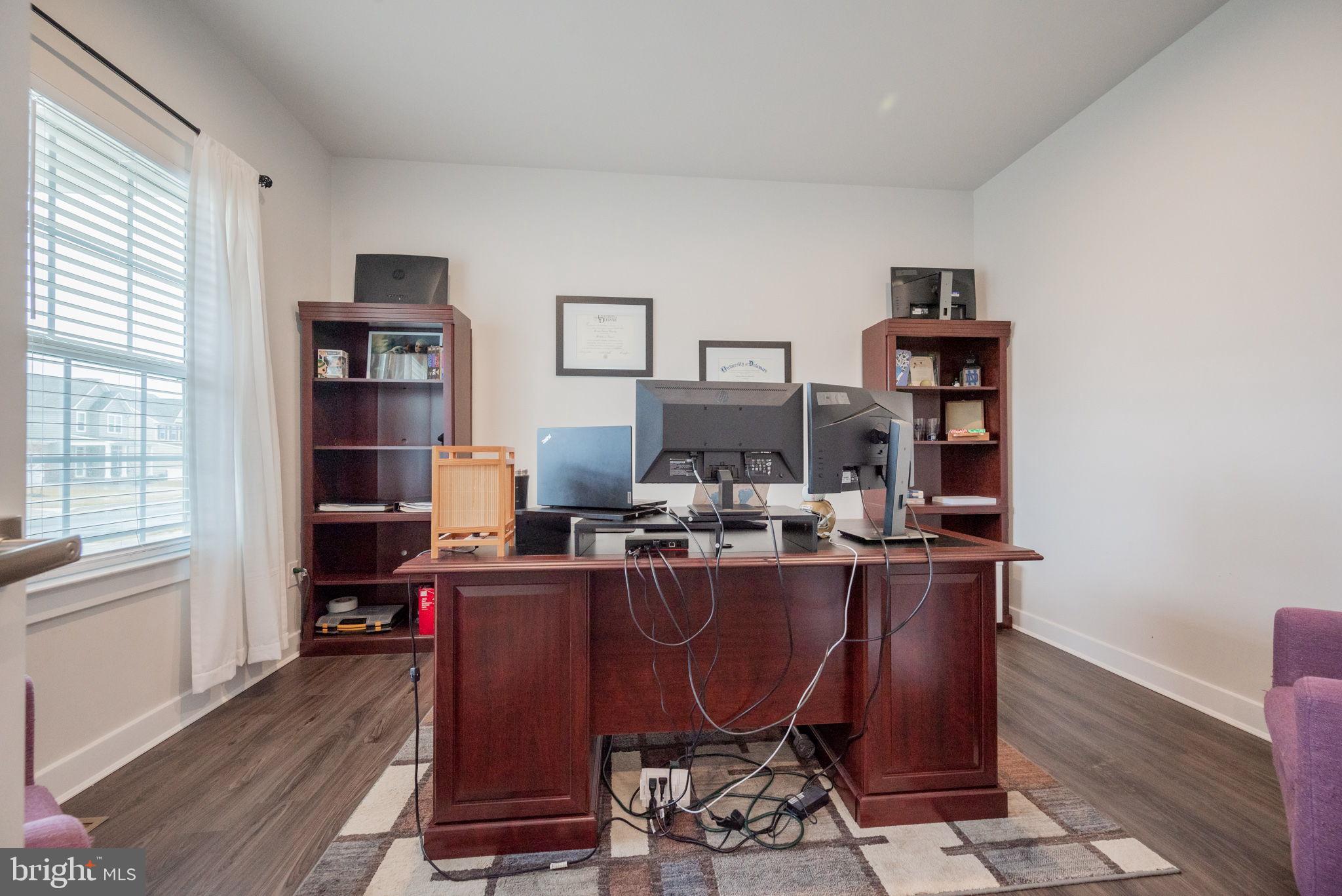 772 Wallasey Drive Middletown, DE 19709 - Photo 4 of 60 a view of a workspace with furniture and a bookshelf