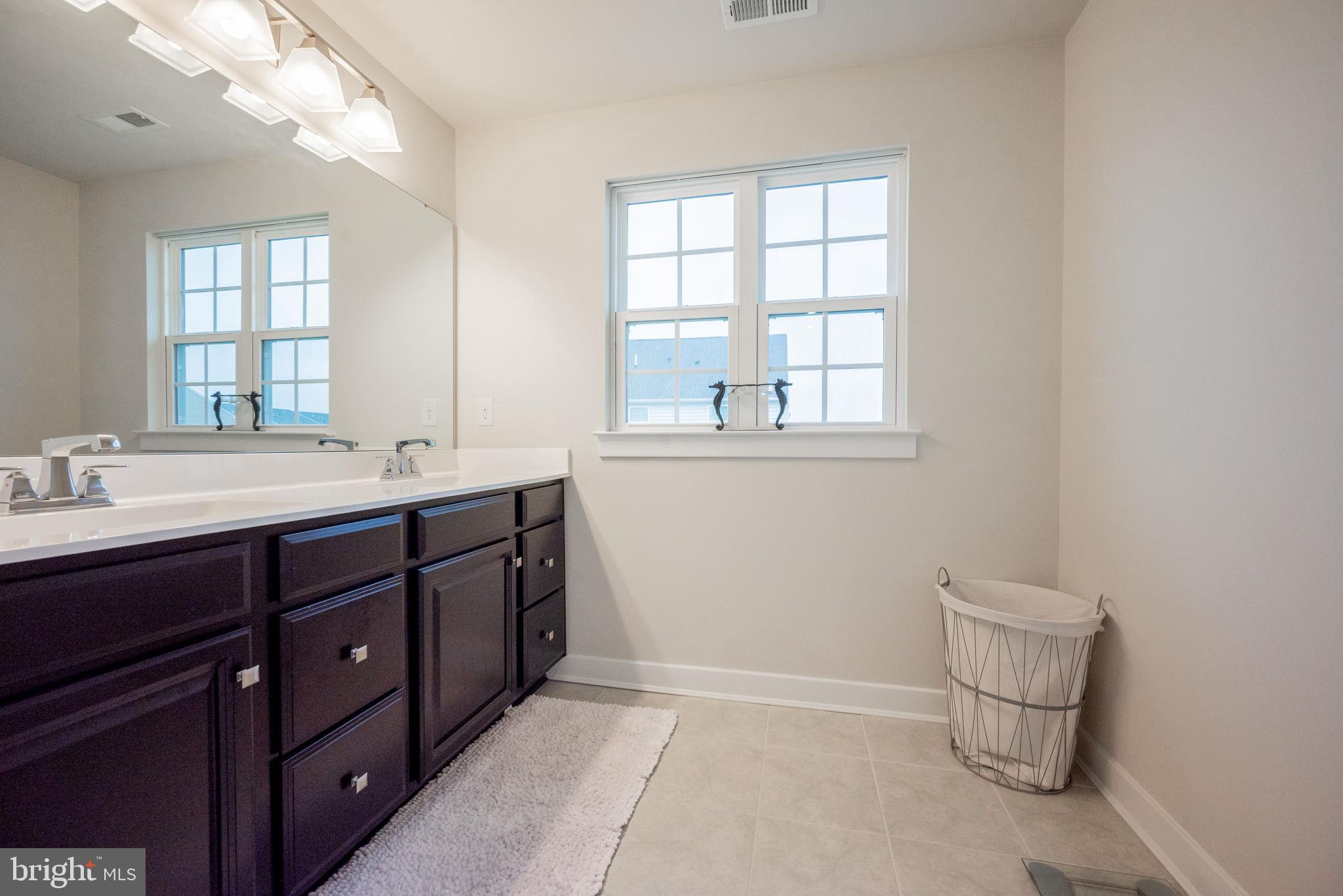 772 Wallasey Drive Middletown, DE 19709 - Photo 55 of 60 a bathroom with a double vanity sink a toilet and a window