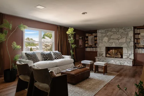 a living room with furniture a large window and a fireplace