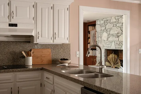 a kitchen with granite countertop a sink a stove and cabinets