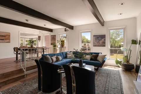a living room with furniture wooden floor and a large window