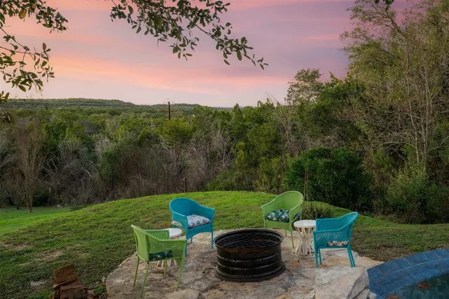 a view of an outdoor space with a table and chairs under an umbrella