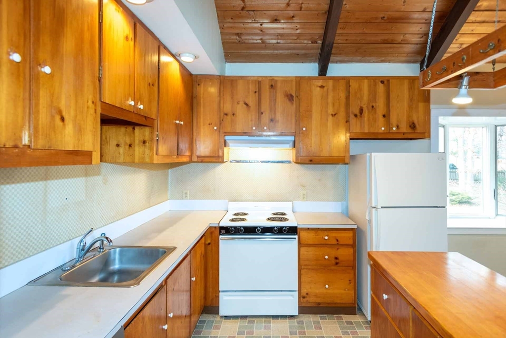 17 Chapman Lane Edgartown, MA 02539 - Photo 11 of 26 a kitchen with a sink a refrigerator and cabinets