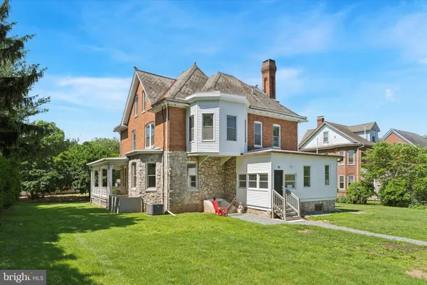 a view of a big house with a yard and plants