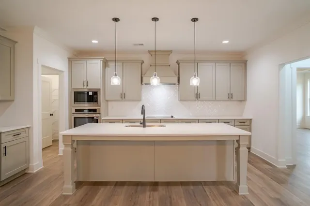 a kitchen with kitchen island a sink stainless steel appliances and wooden floor