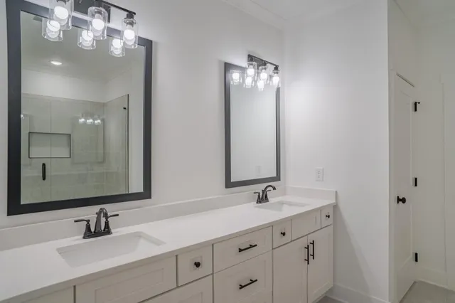 a bathroom with double vanity sinks and a mirror