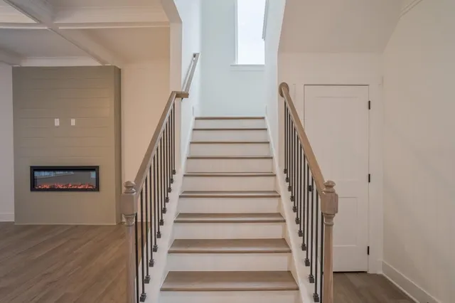 a view of staircase with wooden floor and white walls