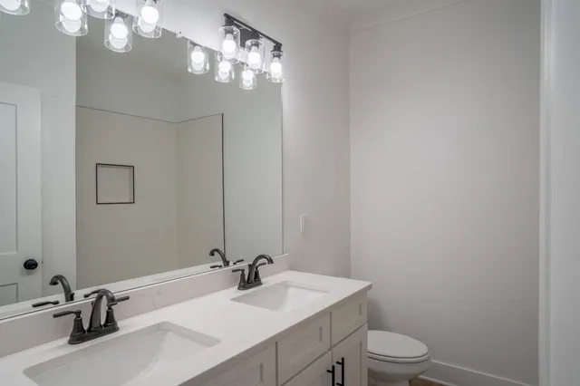 a bathroom with a sink vanity granite and toilet