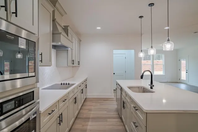 a kitchen with granite countertop a sink and a stove