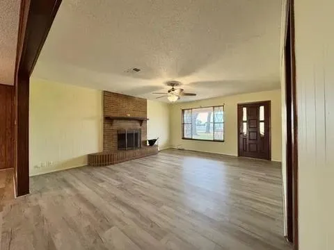 a view of an empty room with window and fire place