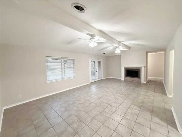 an empty room with windows and a fireplace