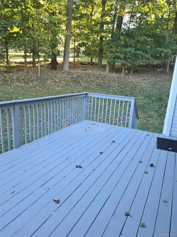 a balcony with wooden floor and yard in the back